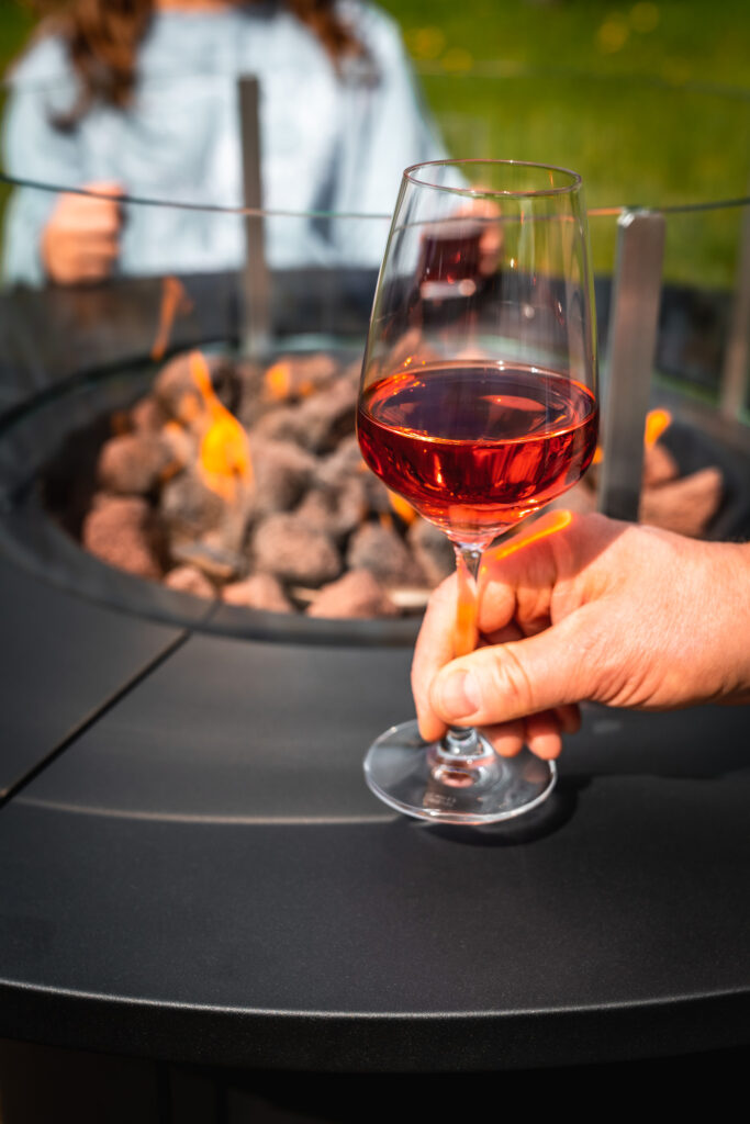 Glas Wein am Feuertisch und Kohlegrill von Meateor